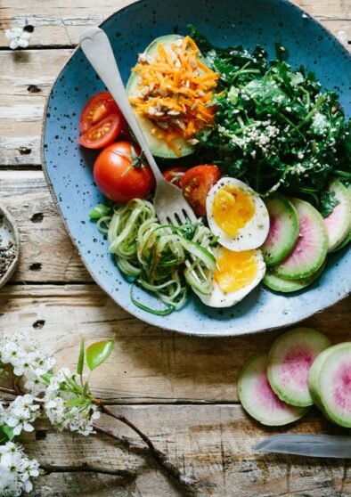 poached egg with vegetables and tomatoes on blue plate