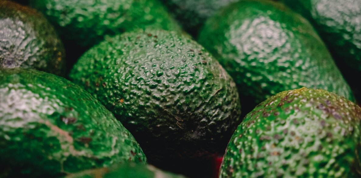 a pile of green avocados sitting next to each other